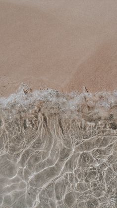 the sand and water are very close to each other on the beach, as seen from above