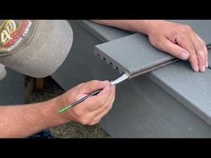 a man is working on an outdoor bench with a green marker in his left hand