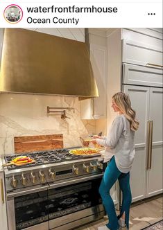 a woman is standing in front of an oven with food on it and the words waterfront farmhouse house ocean county above her