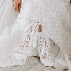 the bride's wedding dress and shoes are all covered in white lace, which is part of her bridal gown