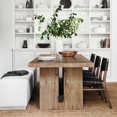 a wooden table sitting in front of a white book shelf