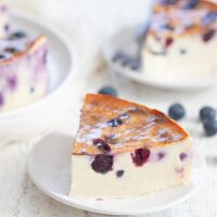 a piece of cheesecake on a plate with blueberries