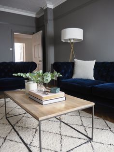 a living room with two blue couches and a coffee table in front of it