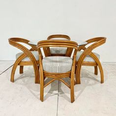 a set of four chairs and a table in the middle of a room with tile flooring