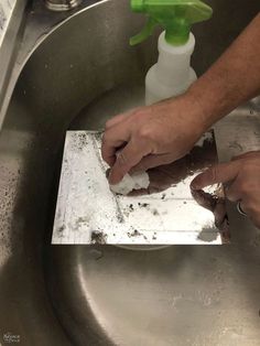 a man is cleaning his hands in the sink with soap and water on top of it