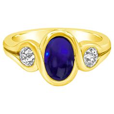 A appealing gemstone fashion ring showcasing a 2.50 carat oval shape blue sapphire cabochon in the center and an old european cut diamond on each side weighing 0.80 carats total. Set in an integrated bezel, Made in 18K Yellow Gold, Size 7.5 US Style available in different price ranges. Prices are based on your selection. Please contact us for more information. Sapphire Cabochon, Stone Fashion, Blue Sapphire Diamond, European Cut Diamonds, Fashion Ring, Jewelry Rings Engagement, Three Stone, Oval Shape, Ring Verlobung