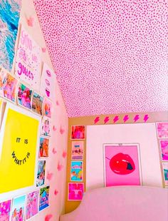 a bedroom with pink walls and pictures on the ceiling