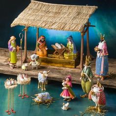 a nativity scene with figurines on the water and people dressed in traditional clothing