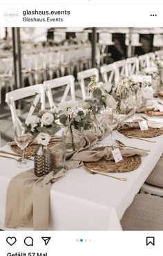 the table is set up with white chairs and place settings for guests to sit at