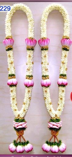 two white and pink garlands with flowers on them