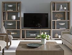 a living room filled with furniture and a flat screen tv on top of a wooden entertainment center