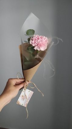 a hand holding a bouquet of pink flowers