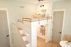 there is a loft bed in the middle of this room with stairs leading up to it