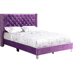 a bed with purple upholstered headboard and white sheets on the bottom side