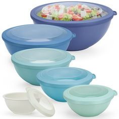 four bowls with lids are stacked on top of each other and one bowl is filled with salad