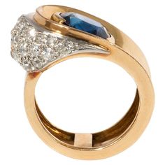 A Retro gold ring of buttoned design centering on an oval sapphire with a pavé diamond segment, in 18k and platinum. Sapphire approx. 3.16 cts.; atw diamonds 1.50 ct. France Current size: 5 5/8" at widest point Asymmetrical Ring, Tanzanite Ring, Retro Jewelry, Fancy Diamonds, Art Deco Diamond, Platinum Ring, Button Design, Sapphire Diamond, Pave Diamonds