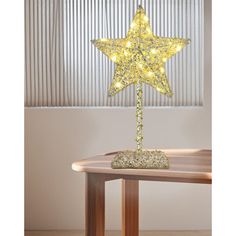 a lighted star on top of a wooden table