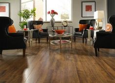 a living room filled with lots of black furniture and decor on top of hard wood flooring