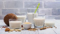 several glasses filled with different types of milk