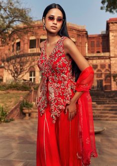 Make a bold entrance in this stunning crimson red chiffon jacket and sharara set, complemented by an elegant organza cape. This ensemble exudes grace and sophistication, perfect for special occasions and festive gatherings. Designer Red Sharara In Chinon, Red Palazzo Set With Sheer Dupatta For Party, Red Georgette Sharara For Party, Festive Red Dress With Cape Sleeves, Red Designer Sets With Cape Sleeves, Red Designer Wear Set With Cape Sleeves, Elegant Red Sharara For Designer Wear, Red Georgette Lehenga For Evening, Traditional Red Sets With Cape Sleeves