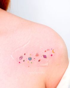 the back of a woman's shoulder with stars and planets on it