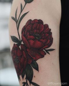 a woman's arm with a red flower tattoo on the left side of her arm