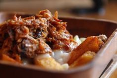 a wooden bowl filled with food on top of a table