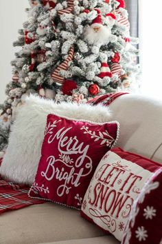 the christmas tree is decorated with red and white pillows