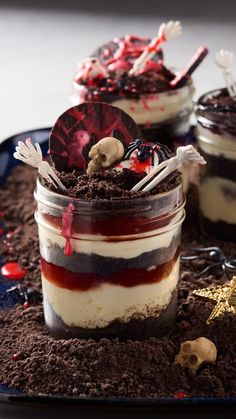 two desserts in glass jars on a plate with chocolate and marshmallows