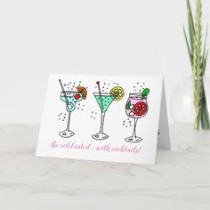 three colorful cocktails on a white card with the words, we celebrate with friends