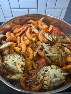 a pan filled with cooked seafood on top of a stove