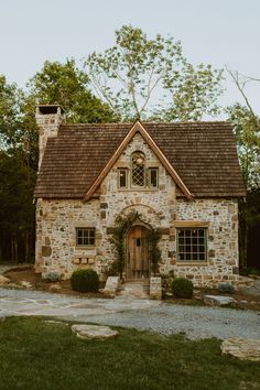 an old stone house with a brown roof