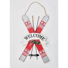 a welcome sign hanging from the side of a wall with skis and snowflakes