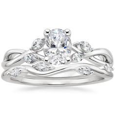 a white gold wedding ring set with an oval cut diamond and leaves on the band