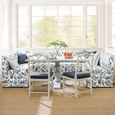 a living room filled with furniture next to a table and chairs in front of a window