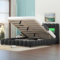 a bed that is sitting on top of a hard wood floor in a living room