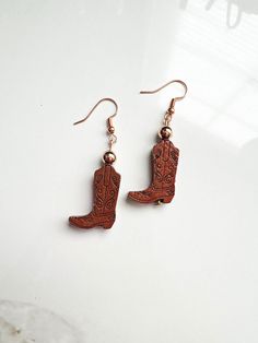 OVERVIEW **These earrings are made with wooden cowboy boot beads, 4mm rose gold beads, set on rose gold/copper ear wires, for pierced ears. ** Custom designed and made in USA. LOOKING FOR EARRINGS? More styles can be found here: https://www.etsy.com/shop/CarbonAndCopper?ref=hdr§ion_id=18041289 SHIPMENT & DELIVERY **All jewelry comes in a custom linen bag and shipped in a padded envelope. **These are ready made and ready to be shipped to you within 1-3 days of purchase. **Domestic Shipping is app Western Style Earrings For Gifts, Cowboy Boot Earrings, Cowgirl Earrings, Boot Earrings, Girl Earrings, Rose Gold Beads, Earrings Rose Gold, Boot Jewelry, Cowboy Boot