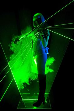 a woman standing in front of green laser lights