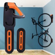 an orange and black bike rack in front of a blue wall