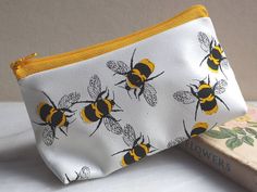 A soft leather white and yellow makeup bag that can also be used as a pencil case or toiletries bag. This charming leather makeup bag has our distinctive bee print in sunny yellow and black printed on white leather. The yellow zip finishes off this lovely leather pouch. The pattern has a really fresh feel and looks great on a dressing table or bathroom shelf.   This would make a great gift for a Mum or Mother-in-law and is perfect for Christmas.  We can gift wrap in a black envelope with gold em Honey Bee Makeup, Bee Makeup, Leather Zip Pouch, Cute Makeup Bags, Leather Makeup Bag, Black Envelopes, Simple Leather, Bee Gifts, Leather Cuts