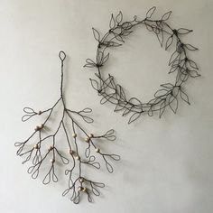 two wire wreaths are hanging on the wall next to each other, one with white beads