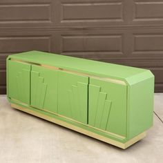 a green cabinet sitting in front of a garage door