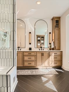 a large bathroom with double sinks and mirrors on the wall, along with two walk in shower stalls