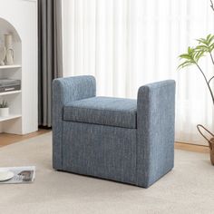 a blue chair sitting on top of a carpeted floor next to a book shelf