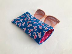 Handmade glasses case made out of a blue cotton flamingo fabric, with a contrasting pink and white cotton polka dot lining. It is lightly padded to protect your glasses. This could also be used as a phone case. The phone in the photos is an iPhone 6s. Approximate size: 3.5in x 7in (9cm x 18cm). Materials: Cotton fabric and fleece padding. Click on the thumbnail images to see more angles. This matches the gift bag set: https://www.etsy.com/uk/listing/1316715696/summer-gift-bags-pool-party-theme-cotton?click_key=e32c53cccfbd07ff001d31425694896a454e84d4%3A1316715696&click_sum=00589a3f&ref=shop_home_active_16&frs=1 Each item is individually wrapped in pink tissue paper and sent in a padded envelope. Items are sent from the UK and we ship worldwide. The basic postage rate means that items canno Fabric Glasses Case, Pool Party Themes, Flamingo Fabric, Flamingo Phone Case, Flamingo Gifts, Pool Bags, Summer Gift, Glasses Case, Bag Set