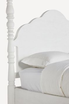 a bed with white linens and pillows on it's headboard, against a white background