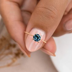 a woman's hand with a blue ring on her finger