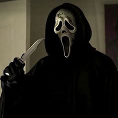 a person wearing a mask and holding a knife in their hand with his mouth open