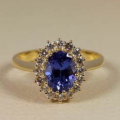 Rosette style engagement ring with an oval shape Tanzanite and full cut (Btiliant cut ) diamonds The center tanzanite ston has an exellent cut and very good color , The weight of the tanzanite is 1.70 ct. and the diamonds total weight is 0.55 ct. It;s a beautiful clasic ring made of 18 ct. solid gold The ring is made in Greece in our workshop in Athens, A special piece of jewelry for special any special occasion For more information about the jewelry we are always in your disposal. Do not hesita Sapphire Engagement Ring Gold, Knit Bracelet, Tanzanite Ring, Coin Ring, Purple Band, Gold Plated Bracelets, Pretty Rings, Engagement Rings Sapphire, Gold Style