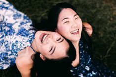 two young women laying on the ground laughing